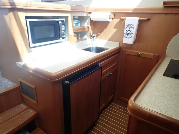 No Quarter Yacht Photos Pics 2006 Mainship 34 Trawler kitchen with microwave, sink, and compact fridge.