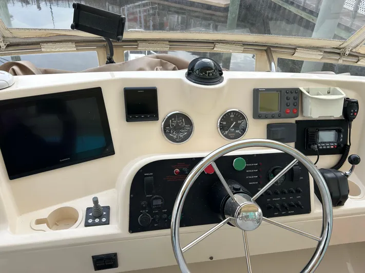 No Quarter Yacht Photos Pics 2006 Mainship 34 Trawler helm with navigation instruments and steering wheel.