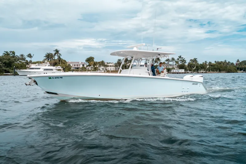  Yacht Photos Pics 2012 Jupiter 34 FS boat cruising on a scenic waterway with palm trees in the background.