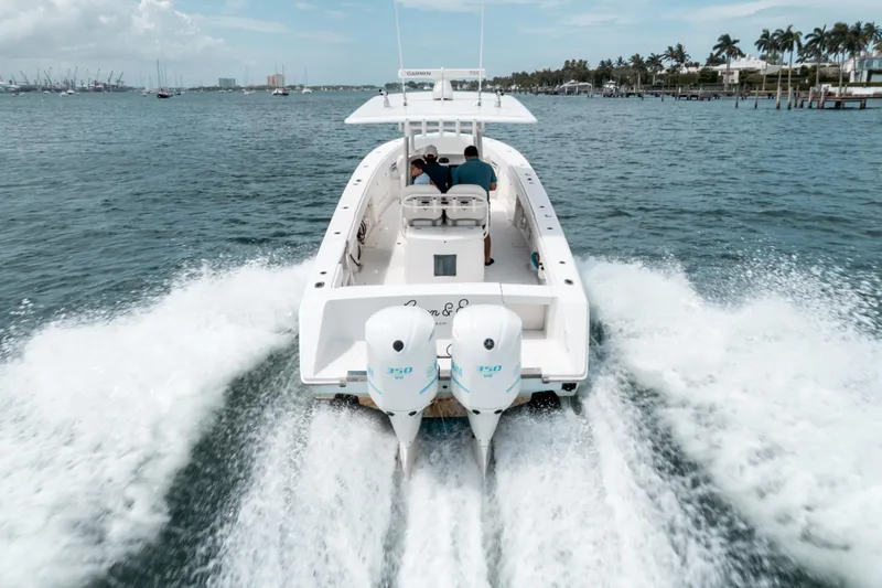  Yacht Photos Pics 2012 Jupiter 34 FS boat cruising on open water, twin engines, palm trees in background.