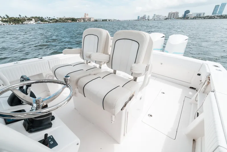  Yacht Photos Pics 2012 Jupiter 34 FS boat interior with steering wheel and seating, overlooking waterfront cityscape.