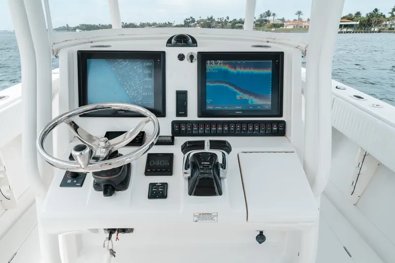  Yacht Photos Pics Control panel of a 2012 Jupiter 34 FS boat with navigation screens and steering wheel.