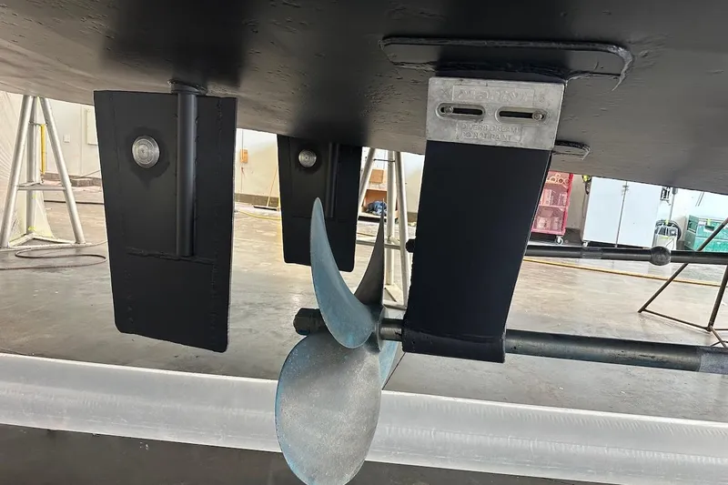 Andiamo Yacht Photos Pics Underside view of a 1991 Broward 102 yacht, showcasing propeller and rudder components.