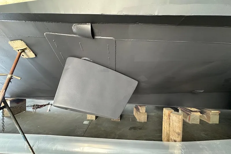 Andiamo Yacht Photos Pics Bottom view of a 1991 Broward 102 yacht with visible rudder and support blocks.