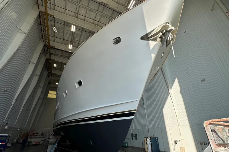 Andiamo Yacht Photos Pics Broward 102 yacht from 1991 in a large indoor facility, viewed from below.