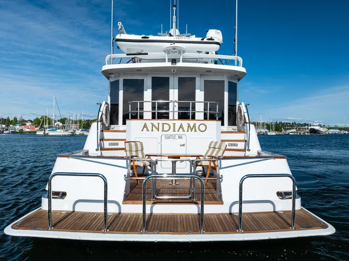 Andiamo Yacht Photos Pics Luxury yacht Broward 102, 1991 model, named Andiamo, docked in a scenic marina.