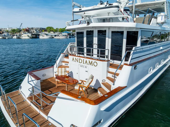 Andiamo Yacht Photos Pics Luxury Broward 102 yacht from 1991, named Andiamo, docked in a serene marina.
