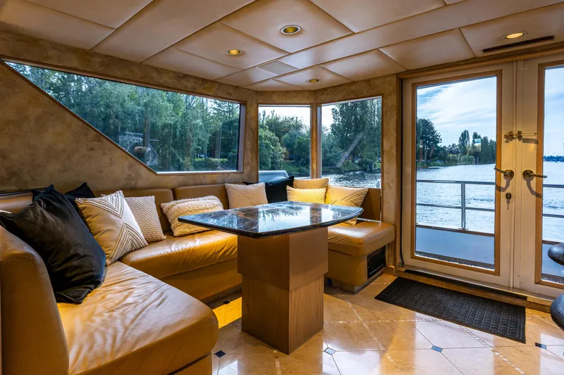 Andiamo Yacht Photos Pics Luxurious Broward 102 yacht interior with leather seating, large windows, and scenic water views.