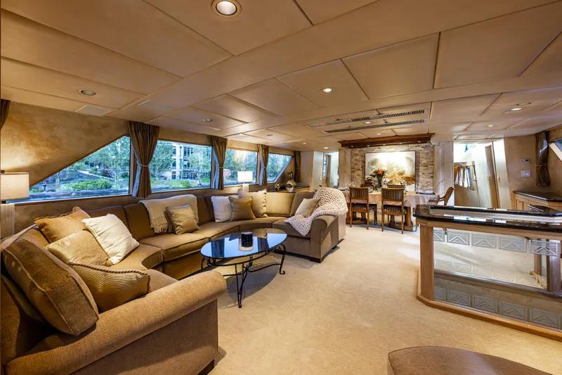 Andiamo Yacht Photos Pics Luxurious interior of 1991 Broward 102 yacht with elegant seating and dining area.