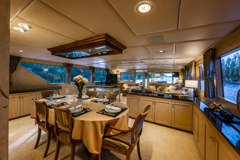 Andiamo Yacht Photos Pics Luxurious interior of 1991 Broward 102 yacht with elegant dining area and scenic windows.