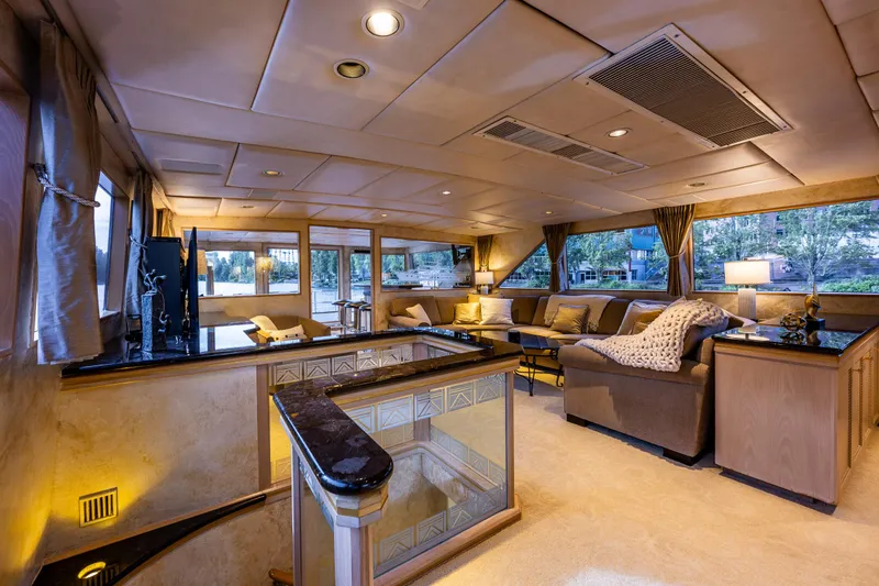 Andiamo Yacht Photos Pics Luxurious interior of 1991 Broward 102 yacht with elegant seating and ambient lighting.