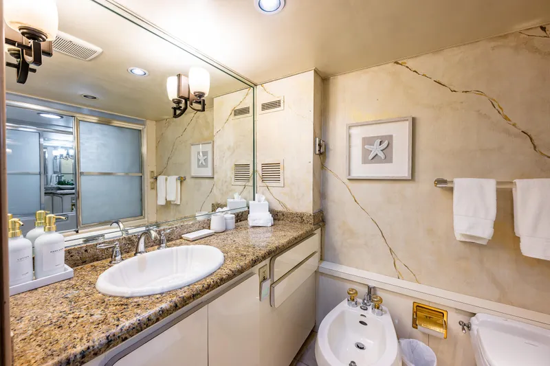 Andiamo Yacht Photos Pics Luxurious yacht bathroom with granite countertop, elegant fixtures, and modern decor, Broward 102, 1991 model.