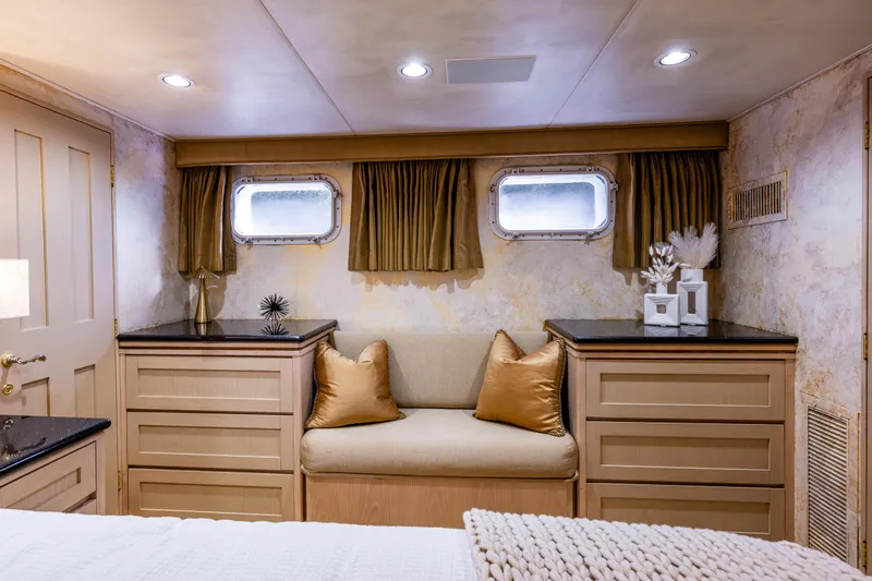 Andiamo Yacht Photos Pics Luxurious cabin interior of a 1991 Broward 102 yacht with elegant decor and cozy seating.