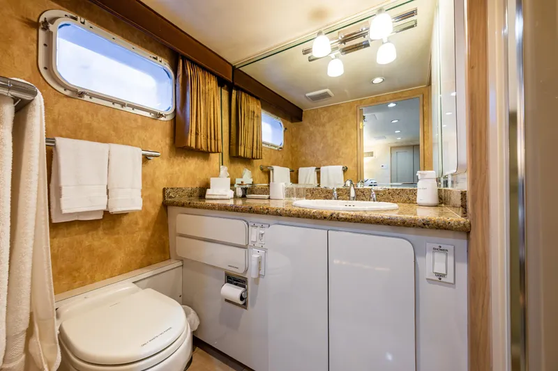 Andiamo Yacht Photos Pics Luxurious bathroom in 1991 Broward 102 yacht with elegant fixtures and ample lighting.