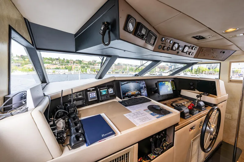 Andiamo Yacht Photos Pics Cockpit of 1991 Broward 102 yacht with navigation equipment and panoramic windows.