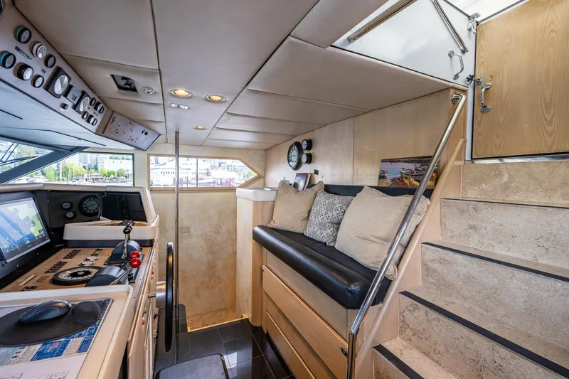 Andiamo Yacht Photos Pics Interior of 1991 Broward 102 yacht with navigation controls and seating area.