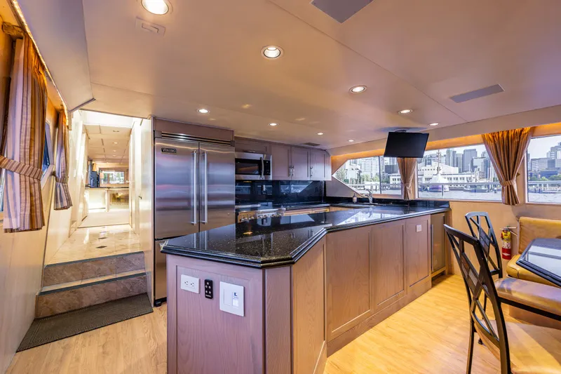 Andiamo Yacht Photos Pics Luxurious kitchen interior of 1991 Broward 102 yacht with modern appliances and elegant design.