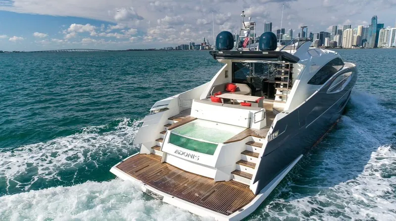  Yacht Photos Pics Luxurious 2019 Numarine 78 yacht cruising near a city skyline on a sunny day.