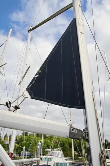  Yacht Photos Pics 2001 Hunter Passage 420 sailboat mast and sail against a cloudy sky.