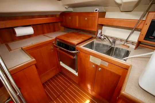  Yacht Photos Pics 2001 Hunter Passage 420 yacht kitchen with wood cabinetry and stainless steel sink.