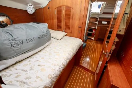  Yacht Photos Pics 2001 Hunter Passage 420 yacht interior with cozy wooden cabin and bed.