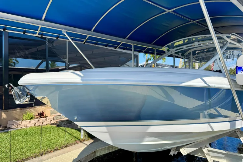  Yacht Photos Pics 2025 Intrepid 327 Cuddy boat under blue canopy, side view.