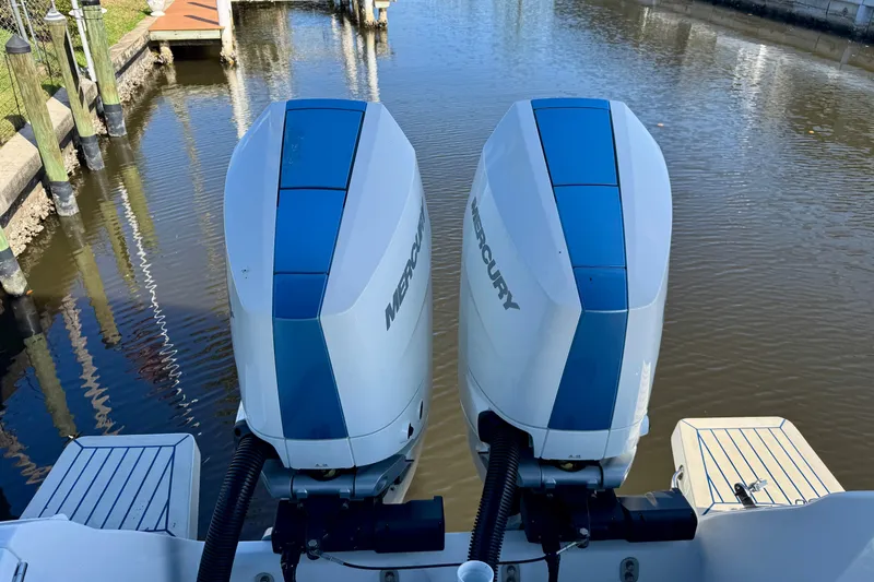  Yacht Photos Pics Twin Mercury outboard engines on a 2025 Intrepid 327 Cuddy boat, docked in calm waters.