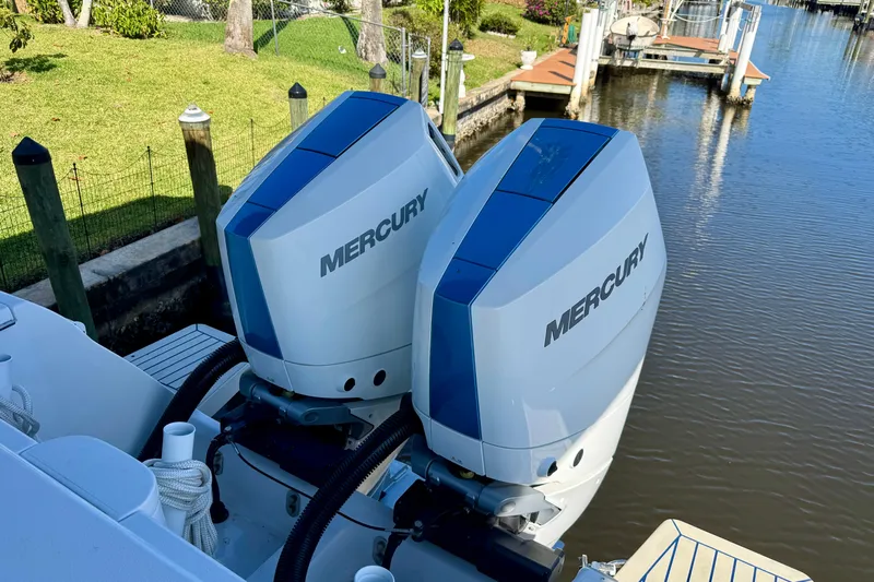  Yacht Photos Pics Twin Mercury outboard engines on a 2025 Intrepid 327 Cuddy boat docked by a canal.