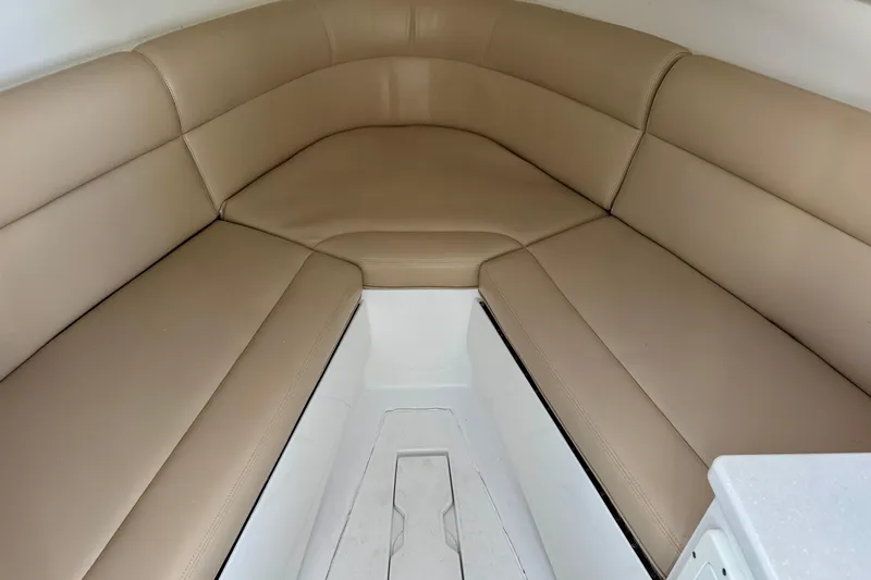  Yacht Photos Pics 2025 Intrepid 327 Cuddy interior with beige cushioned seating.