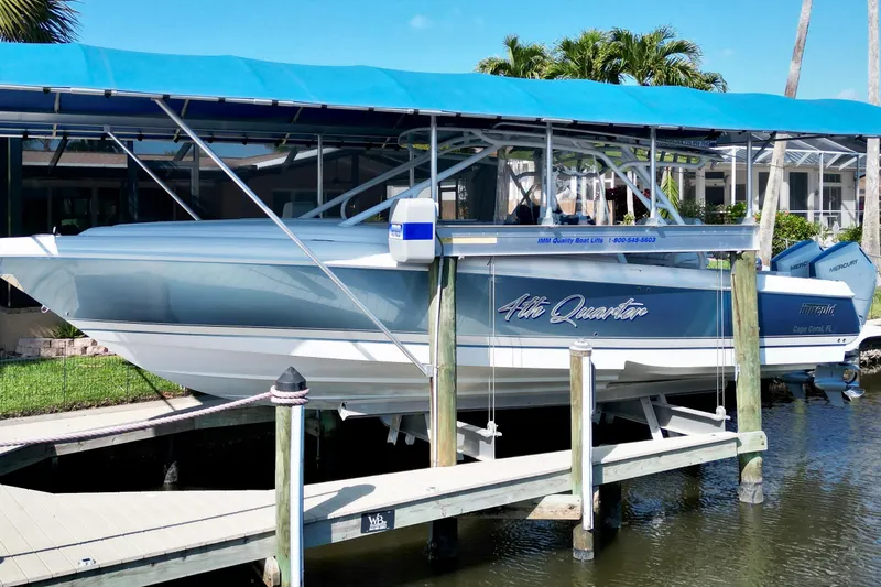  Yacht Photos Pics 2025 Intrepid 327 Cuddy boat docked under blue canopy in sunny marina.