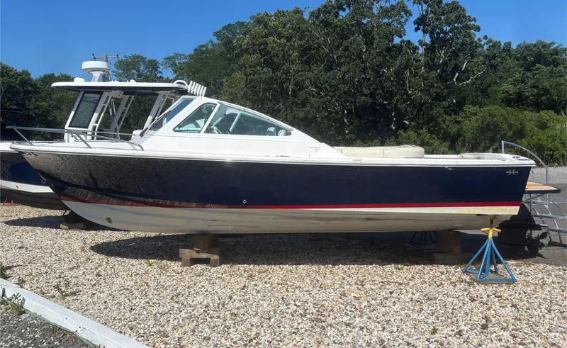  Yacht Photos Pics 2015 Hunt Yachts Harrier 25 Sport boat on gravel, surrounded by trees.