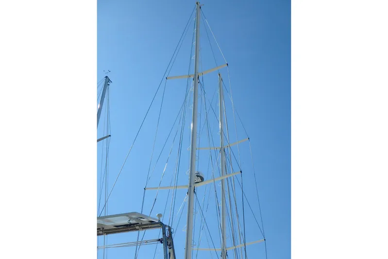 Si J'avais Su Yacht Photos Pics Tall mast of 2017 Custom Gilbert Caroff Lex Eterna 47 sailboat against clear blue sky.