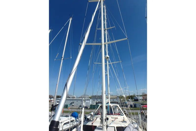 Si J'avais Su Yacht Photos Pics Sailboat mast of 2017 Custom Gilbert Caroff Lex Eterna 47 against clear blue sky.