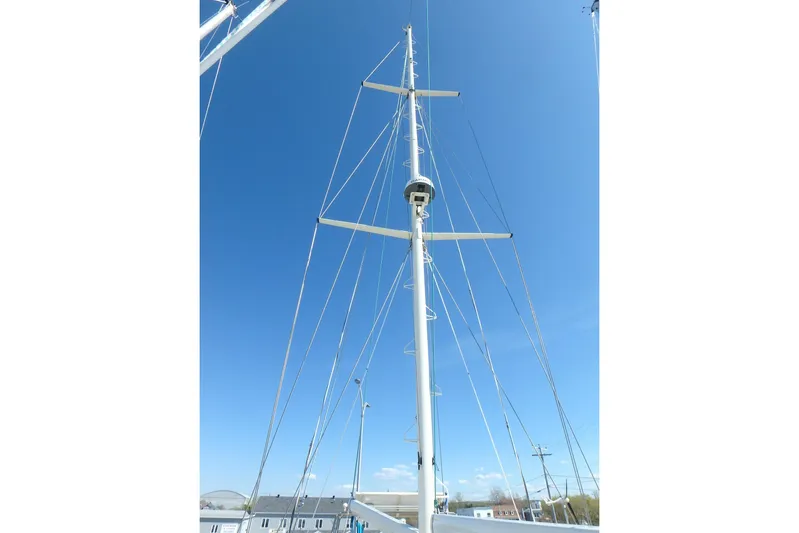 Si J'avais Su Yacht Photos Pics Tall mast of 2017 Custom Gilbert Caroff Lex Eterna 47 sailboat against clear blue sky.