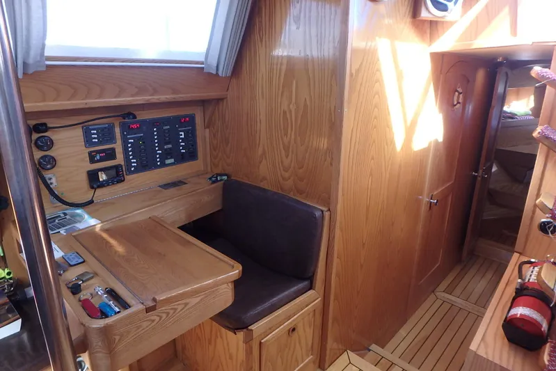 Si J'avais Su Yacht Photos Pics Interior of 2017 Custom Gilbert Caroff Lex Eterna 47 yacht with wooden paneling and navigation station.