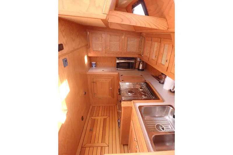 Si J'avais Su Yacht Photos Pics Wooden interior of 2017 Gilbert Caroff Lex Eterna 47 yacht kitchen with stove and sink.