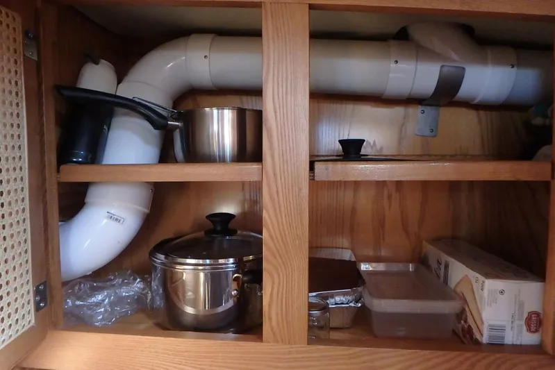 Si J'avais Su Yacht Photos Pics Under-sink storage with pipes, cookware, and containers in a 2017 Gilbert Caroff Lex Eterna 47.