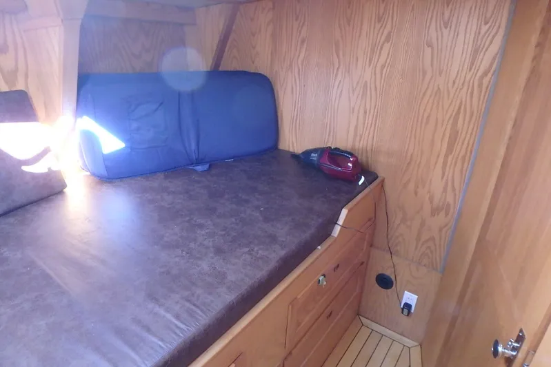 Si J'avais Su Yacht Photos Pics Cozy cabin interior of 2017 Gilbert Caroff Lex Eterna 47 with wooden paneling and bed.