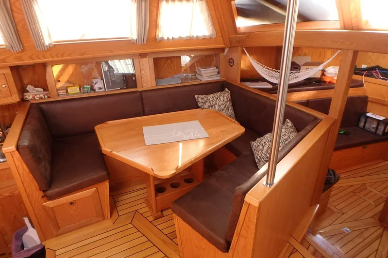 Si J'avais Su Yacht Photos Pics Cozy interior of 2017 Gilbert Caroff Lex Eterna 47 sailboat with wooden dining area.