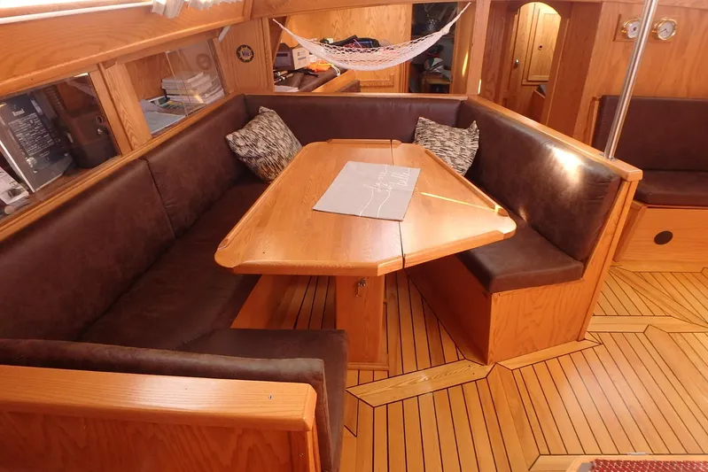 Si J'avais Su Yacht Photos Pics Interior of 2017 Custom Gilbert Caroff Lex Eterna 47 with wooden dining area and cushioned seating.