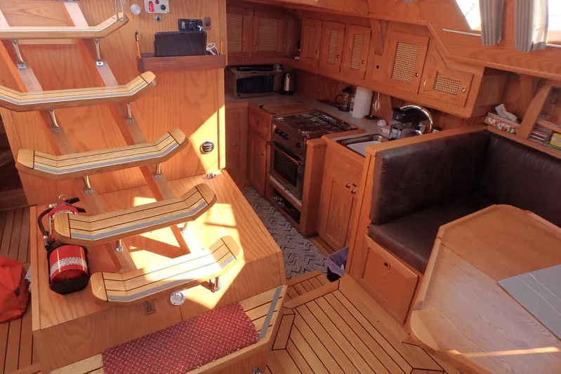 Si J'avais Su Yacht Photos Pics Interior of 2017 Gilbert Caroff Lex Eterna 47 yacht with wooden stairs and cozy kitchen area.