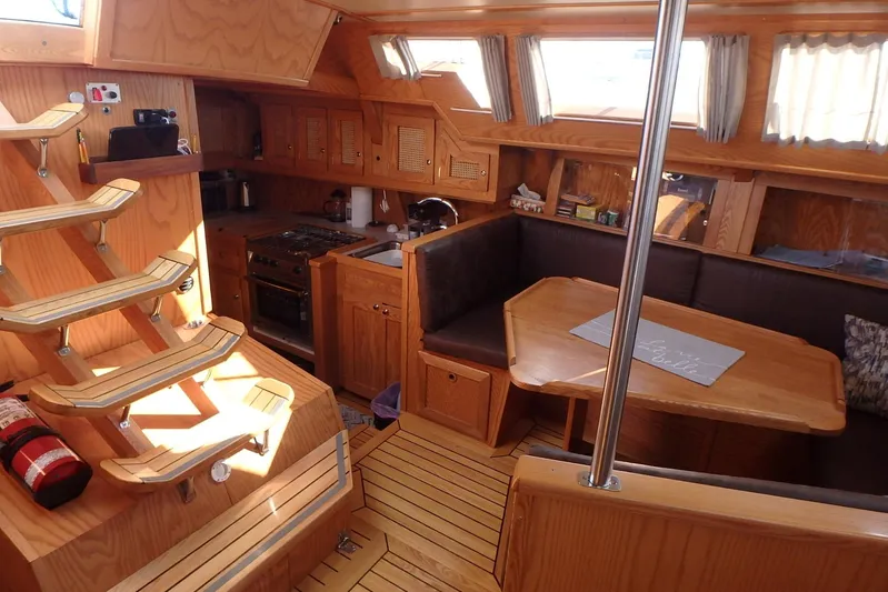 Si J'avais Su Yacht Photos Pics Interior of 2017 Gilbert Caroff Lex Eterna 47 yacht with wooden furnishings and cozy seating area.