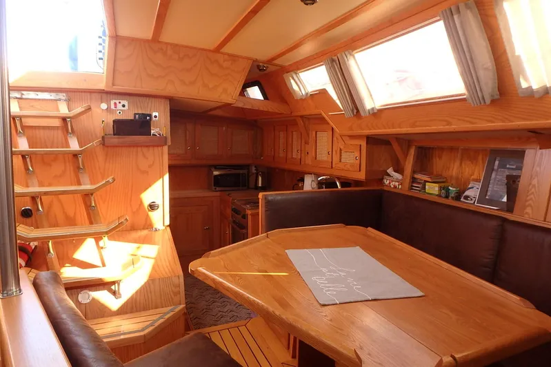 Si J'avais Su Yacht Photos Pics Interior of 2017 Gilbert Caroff Lex Eterna 47 sailboat with wooden furnishings and dining area.