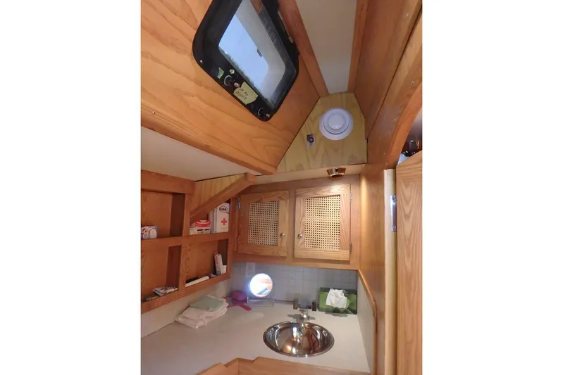 Si J'avais Su Yacht Photos Pics Cozy wooden interior of 2017 Gilbert Caroff Lex Eterna 47 sailboat with sink and storage.