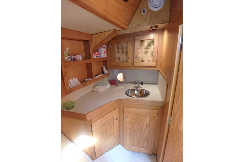 Si J'avais Su Yacht Photos Pics Wooden interior of 2017 Custom Gilbert Caroff Lex Eterna 47, featuring a compact sink and storage.