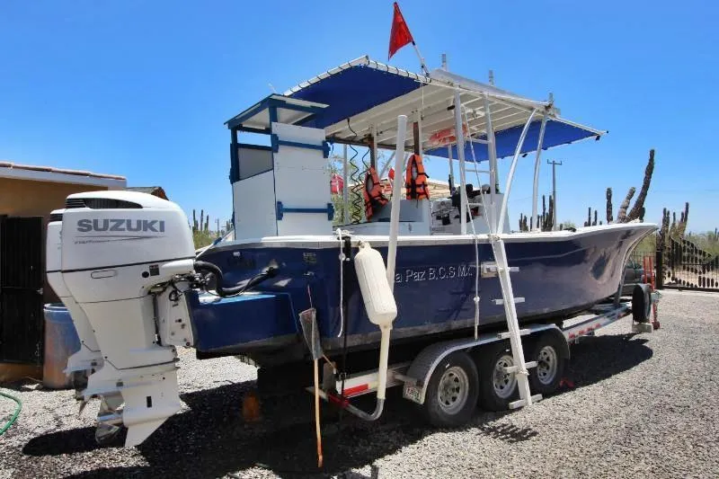  Yacht Photos Pics 2022 Grady-White Canyon 336 boat on trailer with Suzuki outboard motor, parked outdoors.