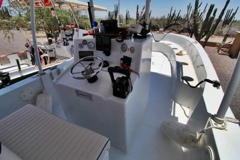  Yacht Photos Pics 2022 Grady-White Canyon 336 boat cockpit with steering wheel and controls, surrounded by desert landscape.