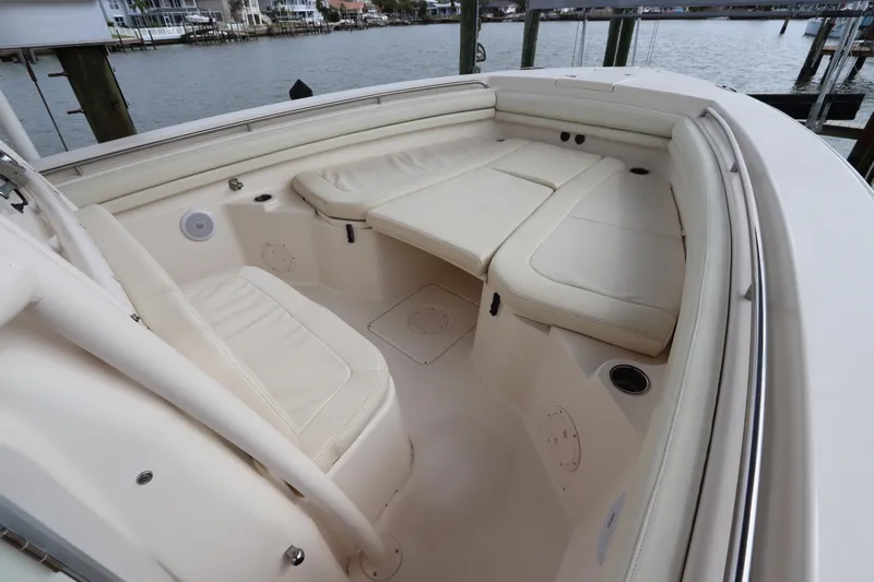  Yacht Photos Pics 2015 Grady-White Canyon 306 boat interior with cushioned seating, docked by the water.