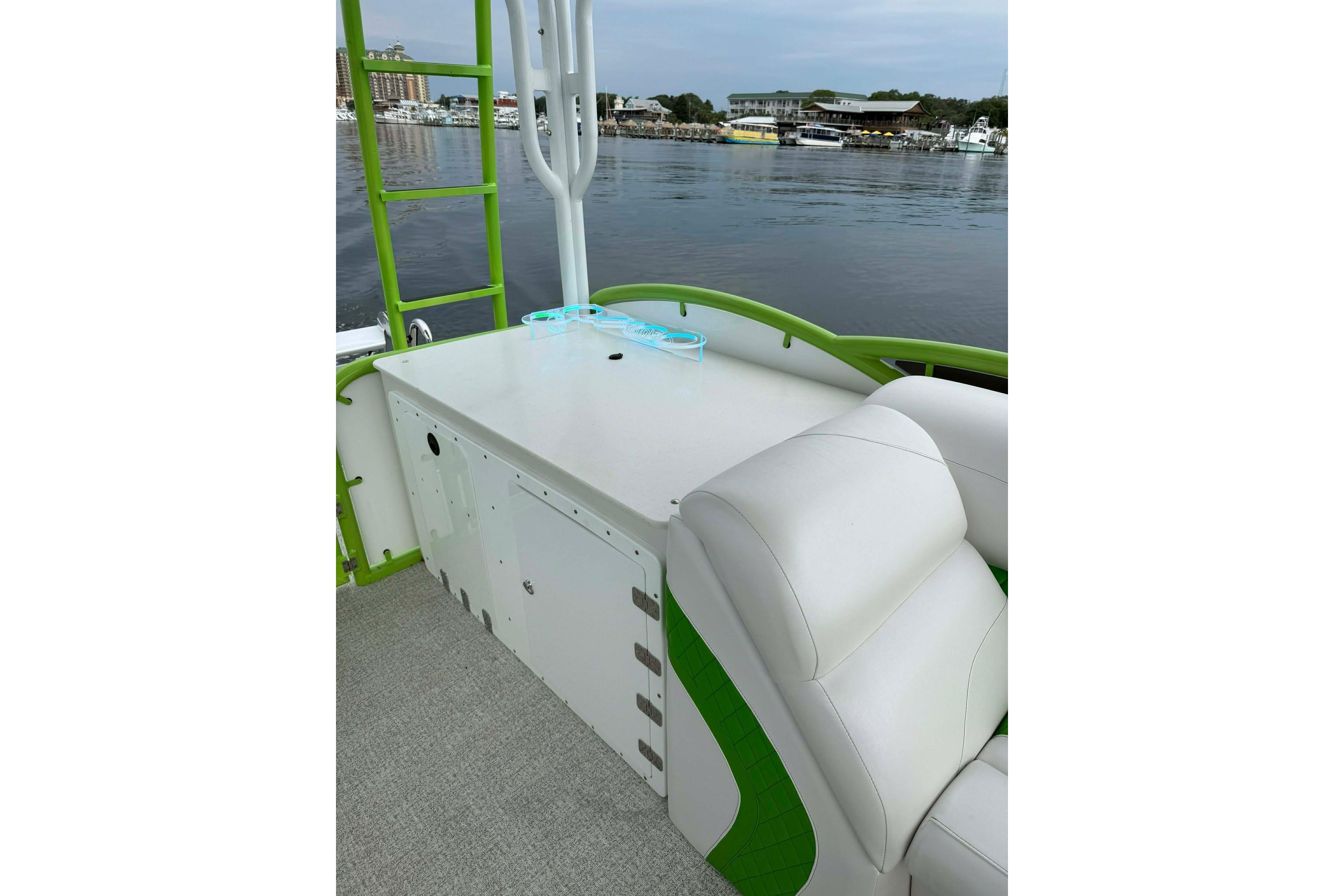 2026 Aloha Pontoon 300 with white seating and green accents on a calm lake.