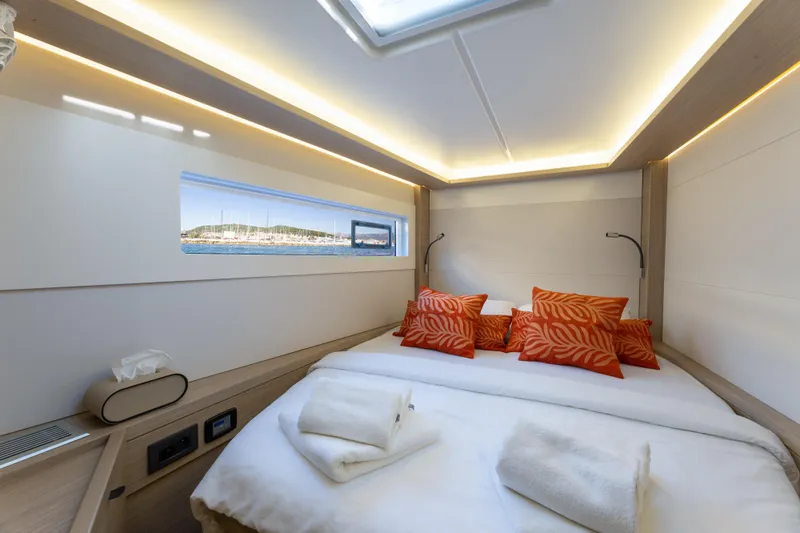 Aura Yacht Photos Pics Luxurious cabin interior of 2024 Lagoon 46 yacht with modern design and vibrant accents.